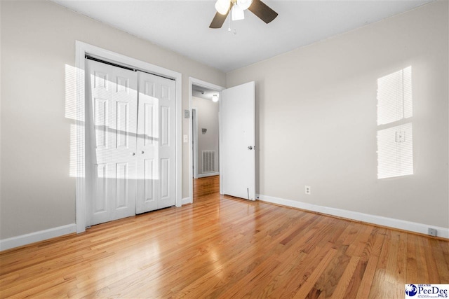interior space featuring visible vents, baseboards, a ceiling fan, and light wood-style floors