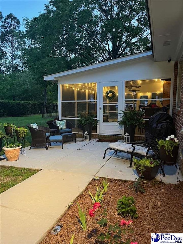 view of patio with an outdoor living space and a sunroom