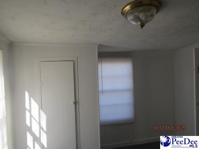 112 N Carolina Ct, Dillon, SC 29536 - unfurnished bedroom with crown molding and multiple windows