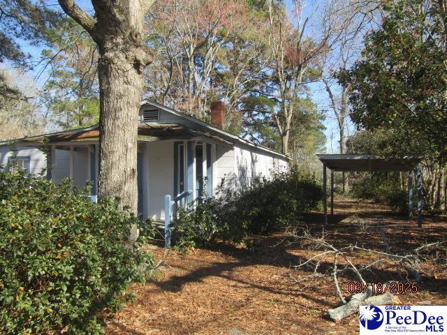 112 N Carolina Ct, Dillon, SC 29536 - view of side of home featuring a chimney