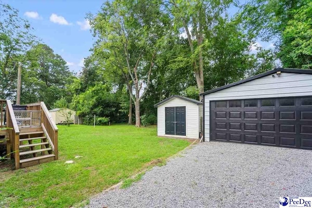 116 Moore St, Bennettsville, SC 29512 - view of grassy yard featuring a deck, a storage unit, view of scattered trees, a detached garage, and stairway