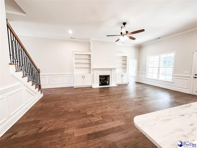 unfurnished living room with crown molding, dark wood-type flooring, and ceiling fan