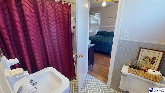 310 S Calhoun Dr, Florence, SC 29501 - ensuite bathroom featuring a shower with curtain, a ceiling fan, a wainscoted wall, and tile walls