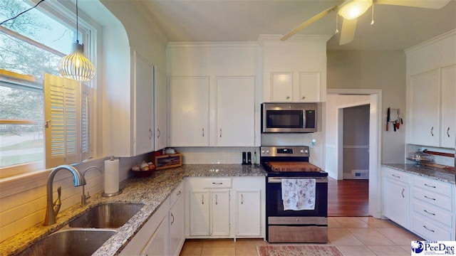 310 S Calhoun Dr, Florence, SC 29501 - kitchen featuring tasteful backsplash, a sink, crown molding, white cabinetry, and stainless steel appliances