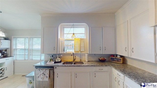 310 S Calhoun Dr, Florence, SC 29501 - kitchen featuring decorative backsplash, stainless steel dishwasher, a sink, and white cabinets