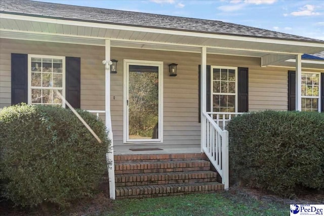 view of exterior entry featuring covered porch