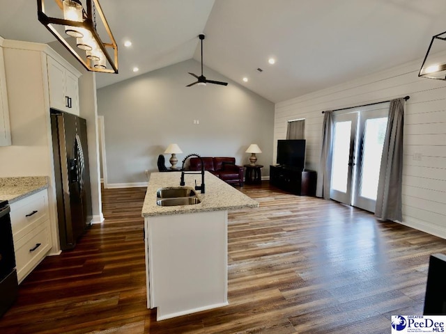 kitchen featuring fridge with ice dispenser, a sink, open floor plan, white cabinets, and dark wood-style flooring