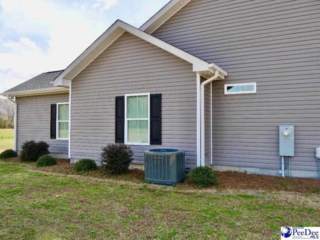 view of home's exterior featuring cooling unit and a lawn