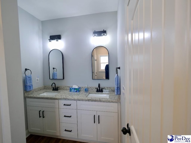 full bathroom with double vanity and a sink