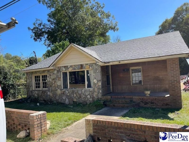 view of front of home with covered porch and a front yard