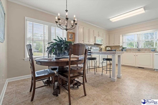 244 Timberlake Dr, Florence, SC 29501 - dining room featuring crown molding, a chandelier, baseboards, and light tile patterned floors