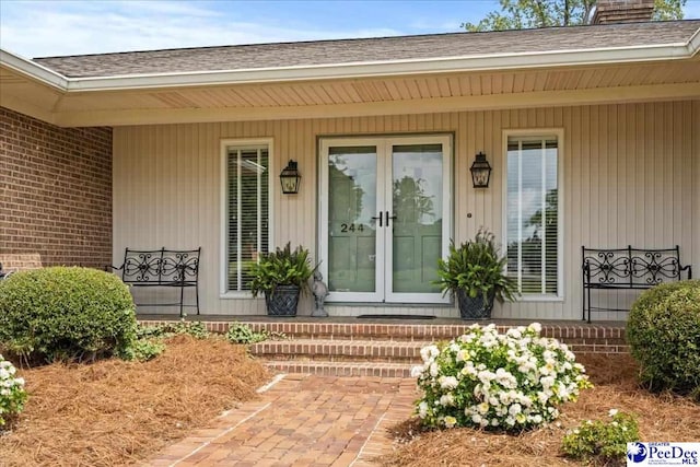 244 Timberlake Dr, Florence, SC 29501 - doorway to property featuring a chimney, french doors, roof with shingles, and covered porch