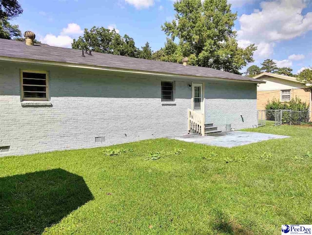 back of house with a patio and a lawn