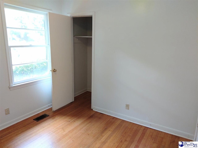 unfurnished bedroom with light hardwood / wood-style floors and a closet