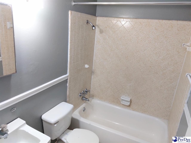 full bathroom with toilet, tiled shower / bath combo, and sink