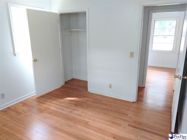 unfurnished bedroom with a closet and light hardwood / wood-style flooring