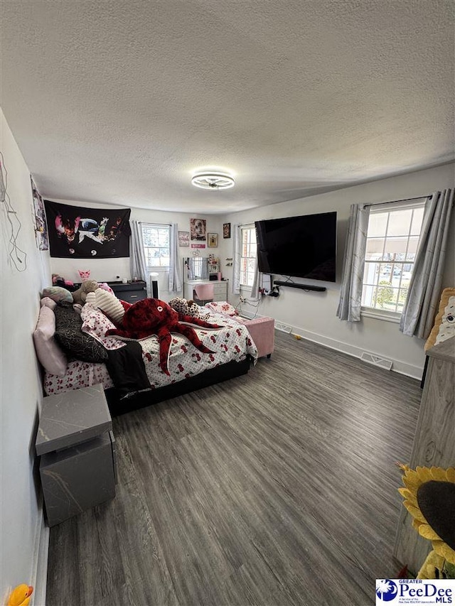 1770 Woods Dr, Florence, SC 29505 - bedroom featuring multiple windows, dark wood finished floors, visible vents, and a textured ceiling