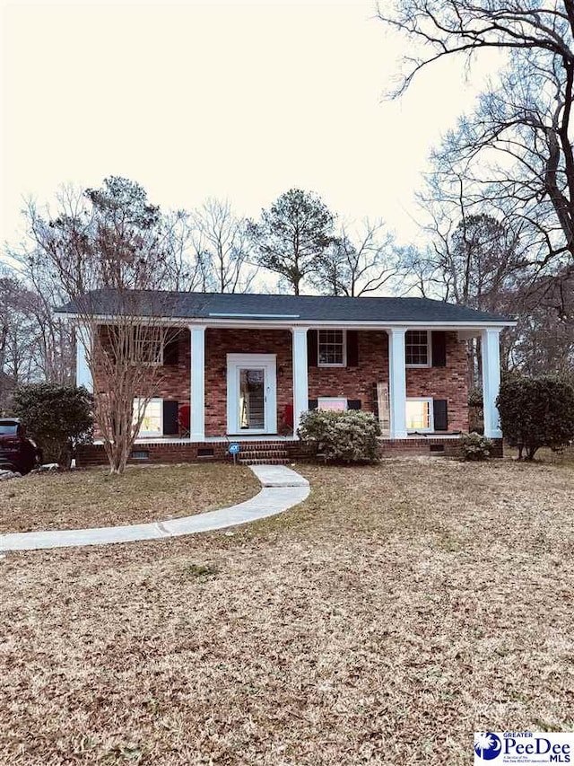 bi-level home with a porch and brick siding