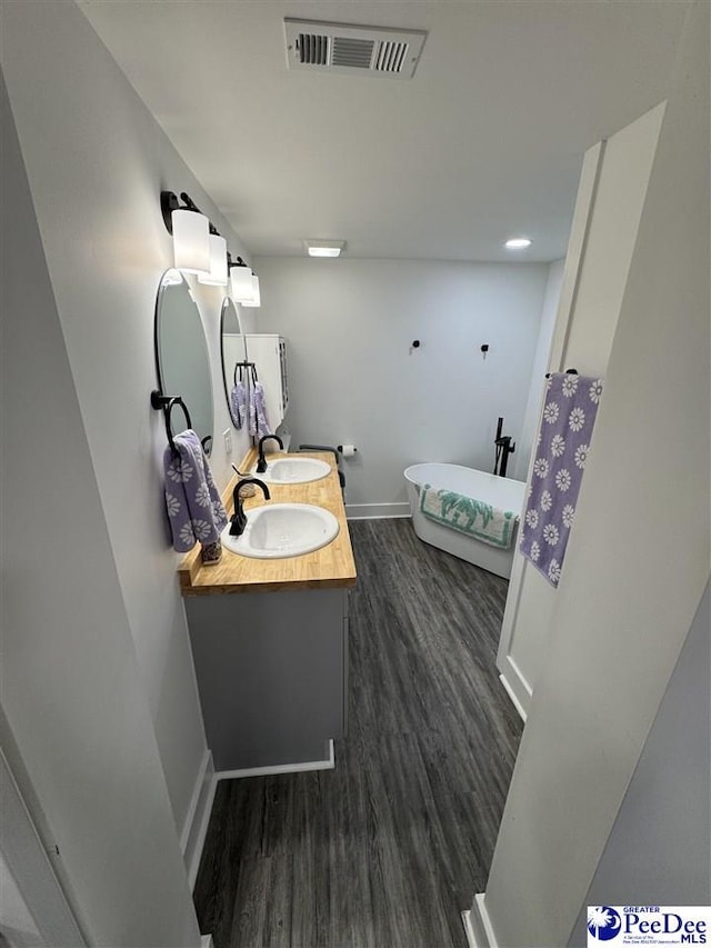 1770 Woods Dr, Florence, SC 29505 - full bath featuring a freestanding tub, visible vents, a sink, and wood finished floors