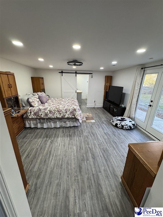 1770 Woods Dr, Florence, SC 29505 - bedroom featuring a barn door, recessed lighting, wood finished floors, access to exterior, and french doors