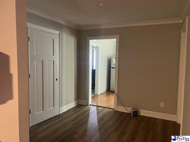 empty room with ornamental molding and dark hardwood / wood-style floors