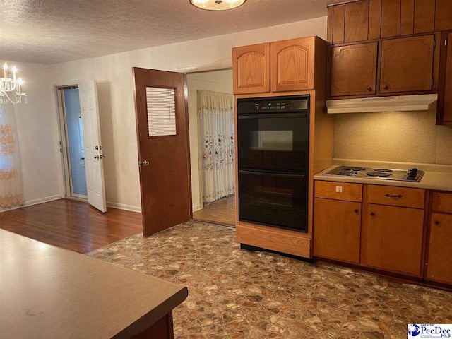 kitchen featuring tasteful backsplash, black double oven, a textured ceiling, and electric cooktop