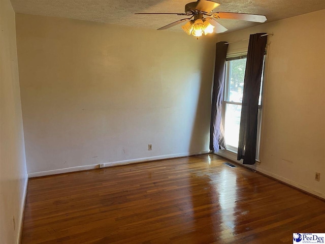 unfurnished room with ceiling fan, a textured ceiling, and dark hardwood / wood-style flooring