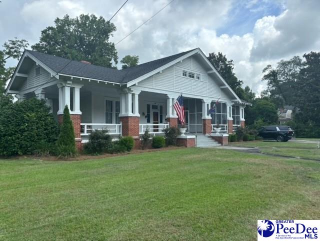 craftsman-style home with covered porch and a front lawn