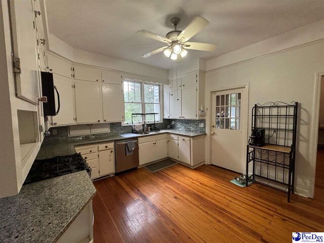 kitchen featuring tasteful backsplash, white cabinets, dark hardwood / wood-style flooring, stainless steel dishwasher, and ceiling fan