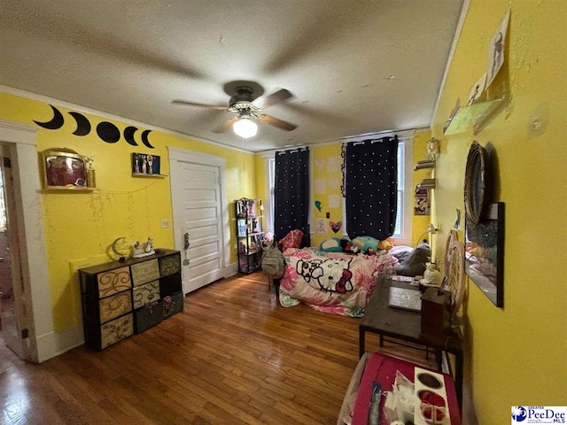 bedroom featuring ceiling fan, dark hardwood / wood-style floors, and a textured ceiling