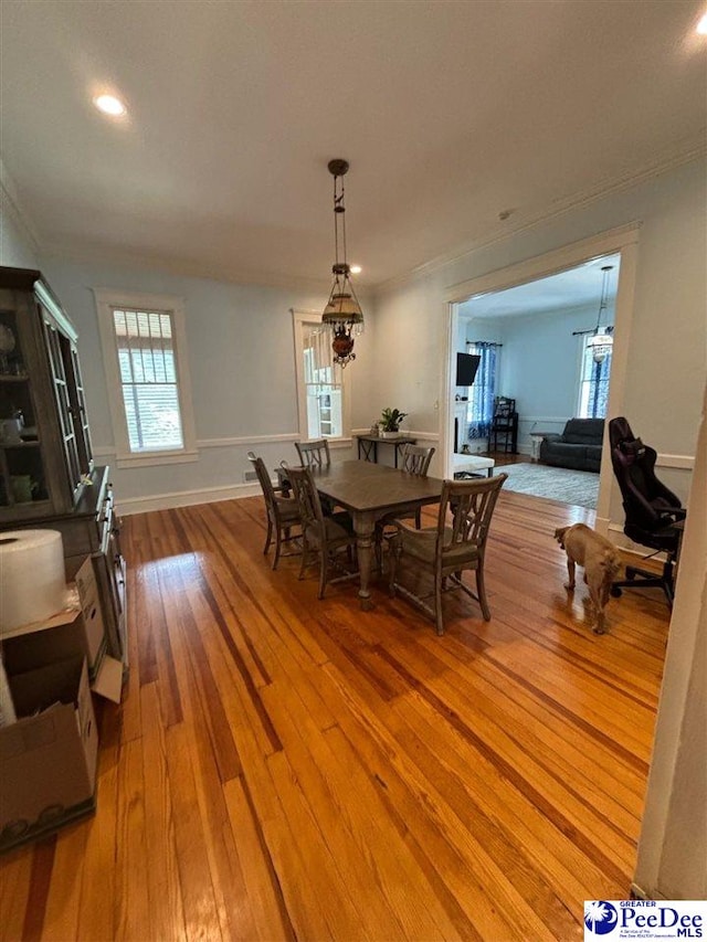 dining space featuring ornamental molding and light wood-type flooring