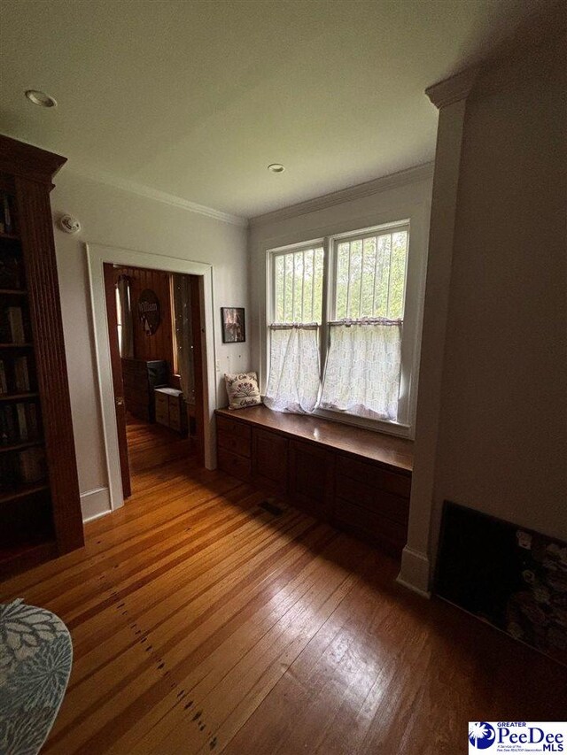 empty room with crown molding and light hardwood / wood-style floors