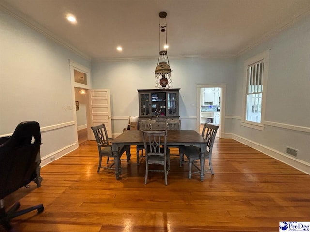 dining area featuring crown molding and hardwood / wood-style floors