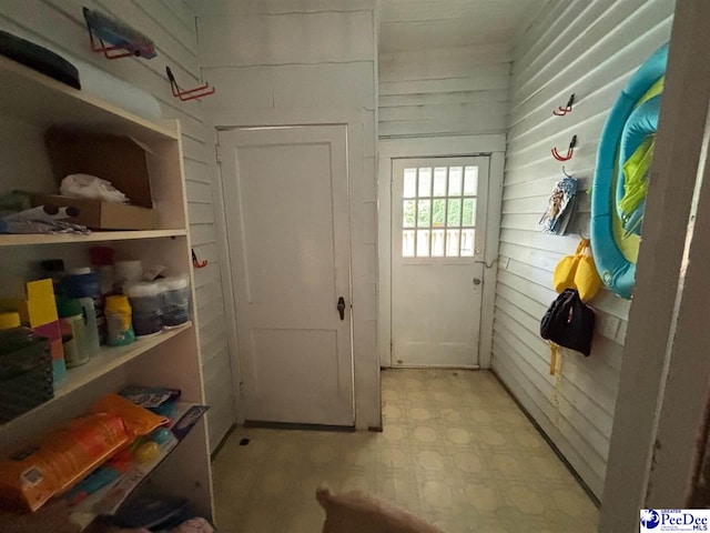 mudroom featuring wooden walls