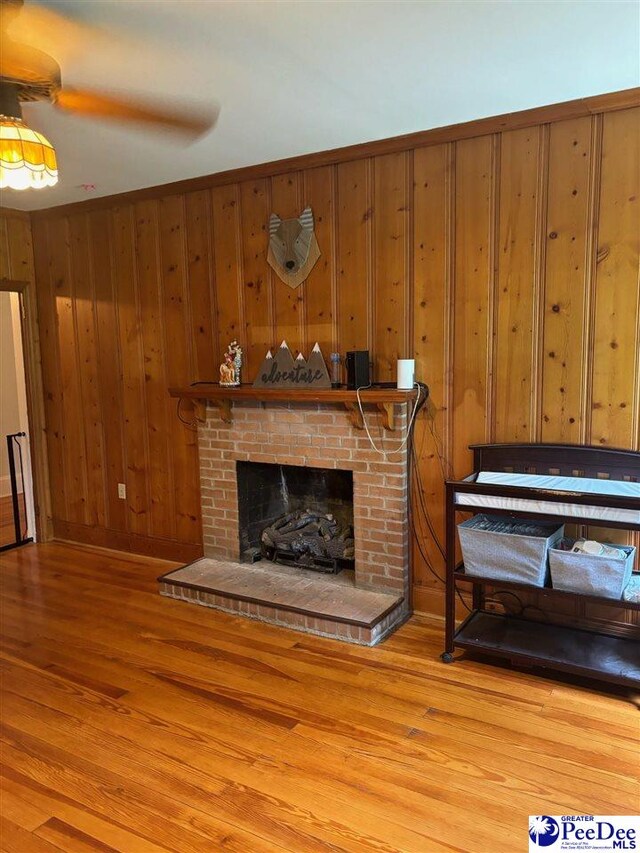 living room featuring hardwood / wood-style floors, a fireplace, and wood walls