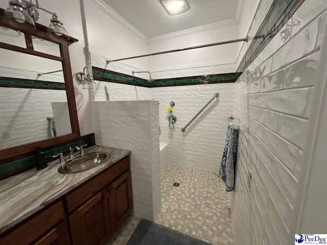 bathroom featuring crown molding, vanity, and a tile shower