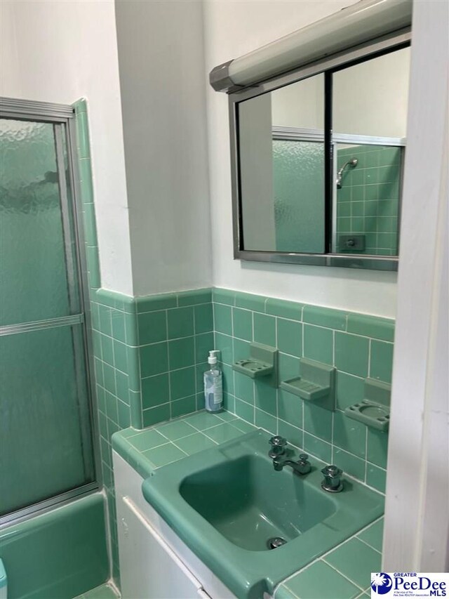 bathroom featuring bath / shower combo with glass door and vanity