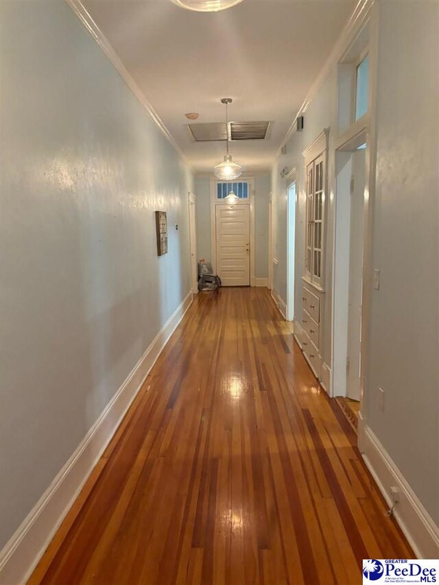 corridor with wood-type flooring and ornamental molding