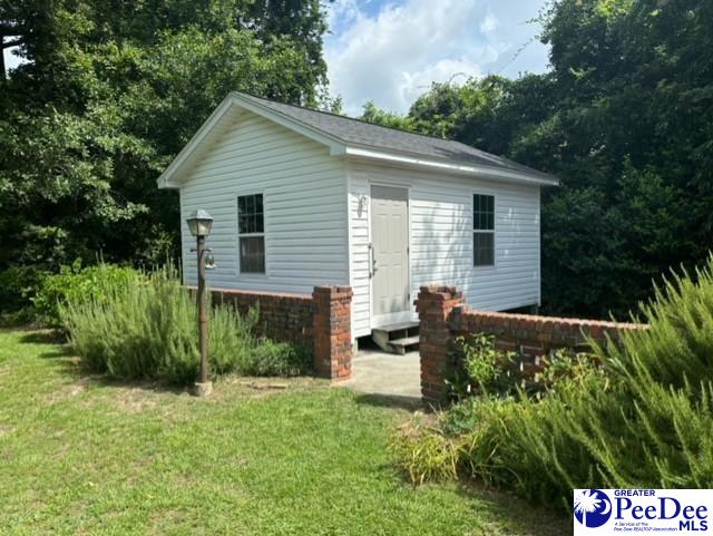 exterior space featuring an outbuilding and a front yard