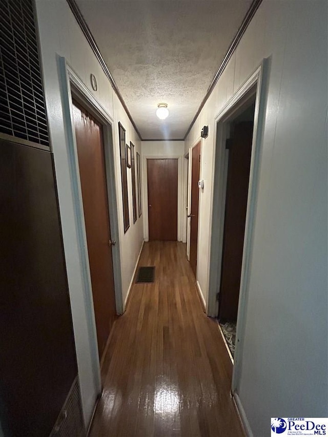 719 Parrish Dr, Mullins, SC 29574 - hallway with crown molding, a heating unit, hardwood / wood-style floors, and a textured ceiling