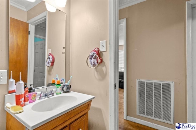bathroom featuring ornamental molding, vanity, and wood finished floors
