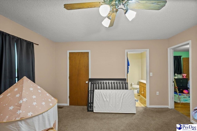 bedroom featuring carpet flooring, a textured ceiling, connected bathroom, baseboards, and a ceiling fan