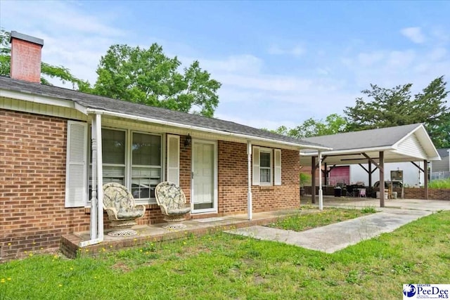 single story home with brick siding, a chimney, and a front lawn