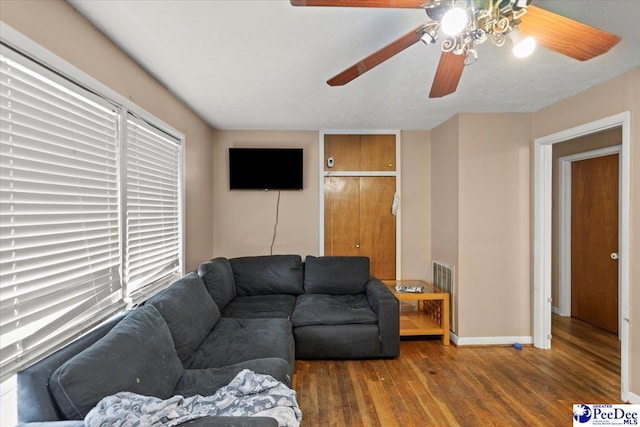 living room with a ceiling fan, wood finished floors, and baseboards