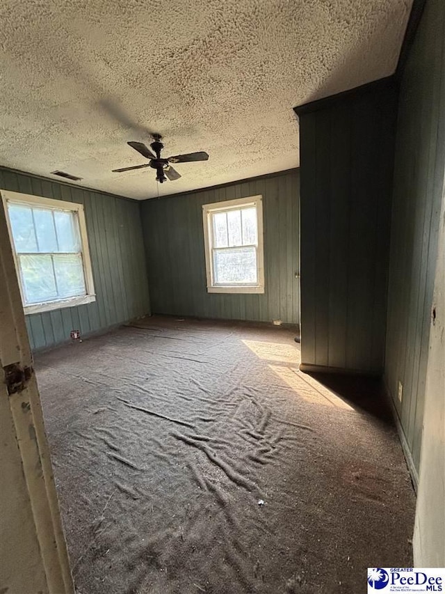 207 W Smith Ave, Darlington, SC 29532 - spare room with ceiling fan, a textured ceiling, carpet, and wooden walls