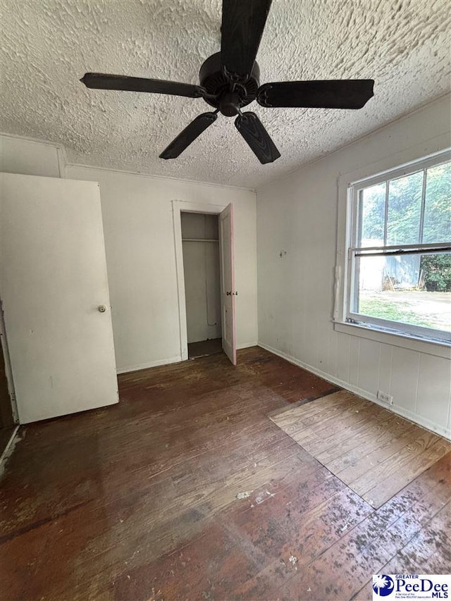 207 W Smith Ave, Darlington, SC 29532 - unfurnished bedroom with wood-type flooring, a textured ceiling, a closet, and ceiling fan