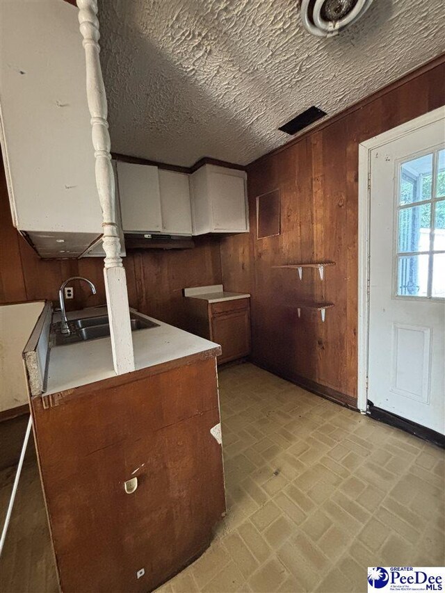 207 W Smith Ave, Darlington, SC 29532 - kitchen with brick patterned flooring, a sink, and wood walls