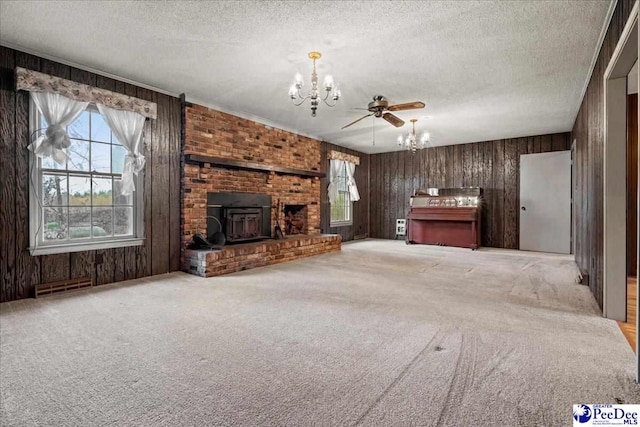 unfurnished living room featuring an inviting chandelier, light colored carpet, wooden walls, and a textured ceiling