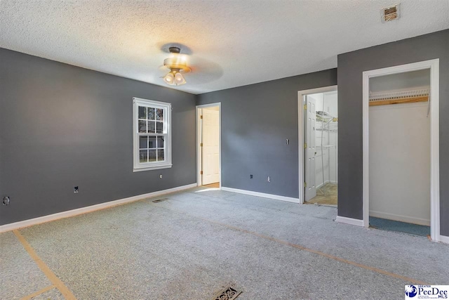 unfurnished bedroom featuring a closet, a textured ceiling, and carpet