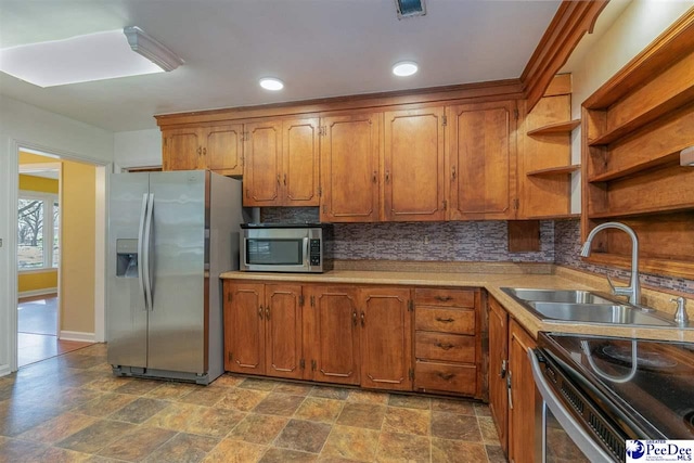 kitchen with sink, backsplash, and appliances with stainless steel finishes